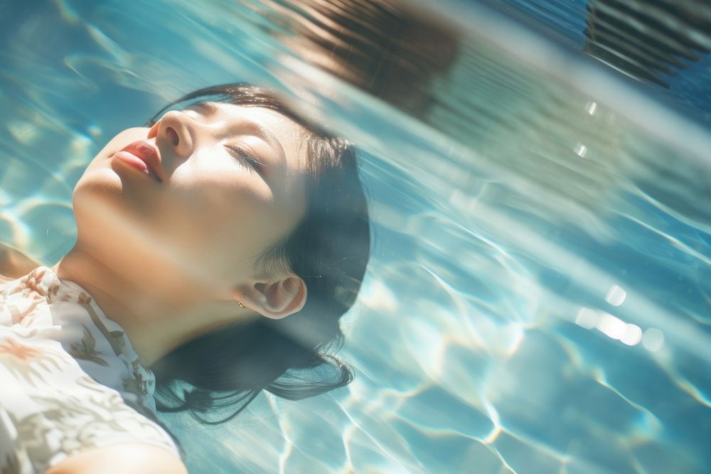 Asian woman laying in a swimming pool reflection portrait outdoors. AI generated Image by rawpixel.