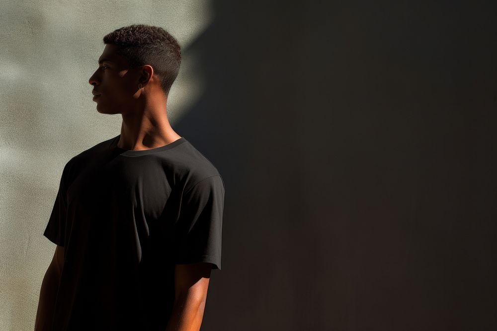 A man in a oversize black t shirt portrait t-shirt shadow. AI generated Image by rawpixel.