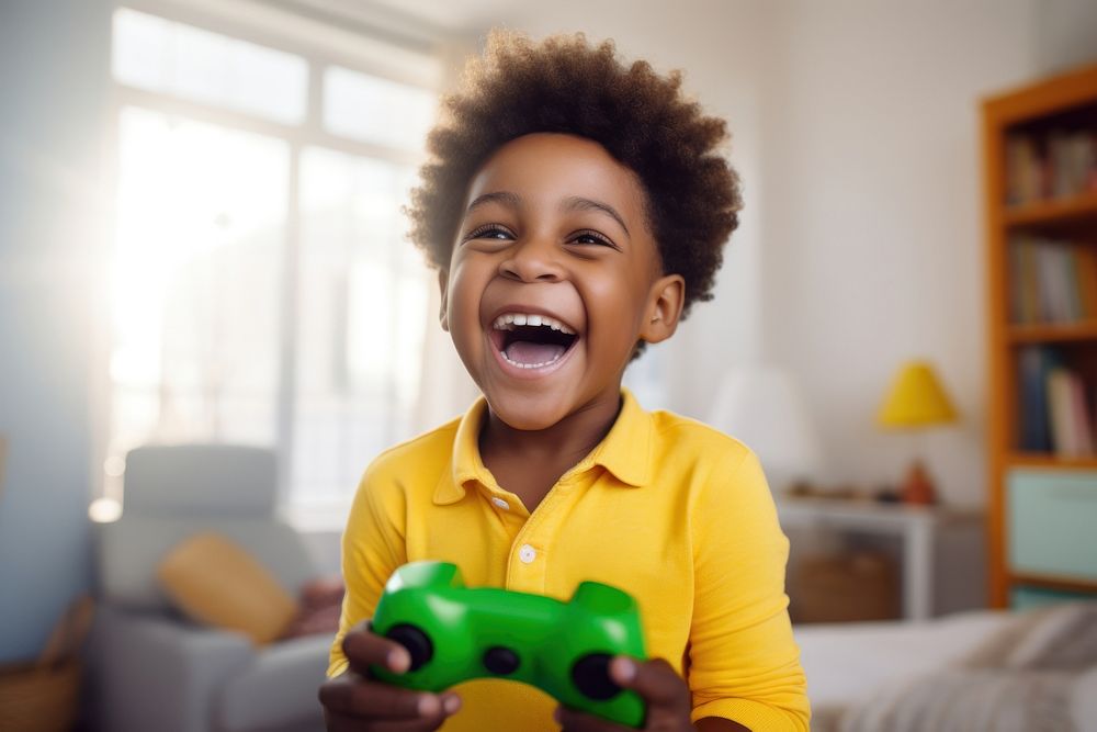 Boy in yellow sweater holding a Game Controller laughing smile baby. AI generated Image by rawpixel.