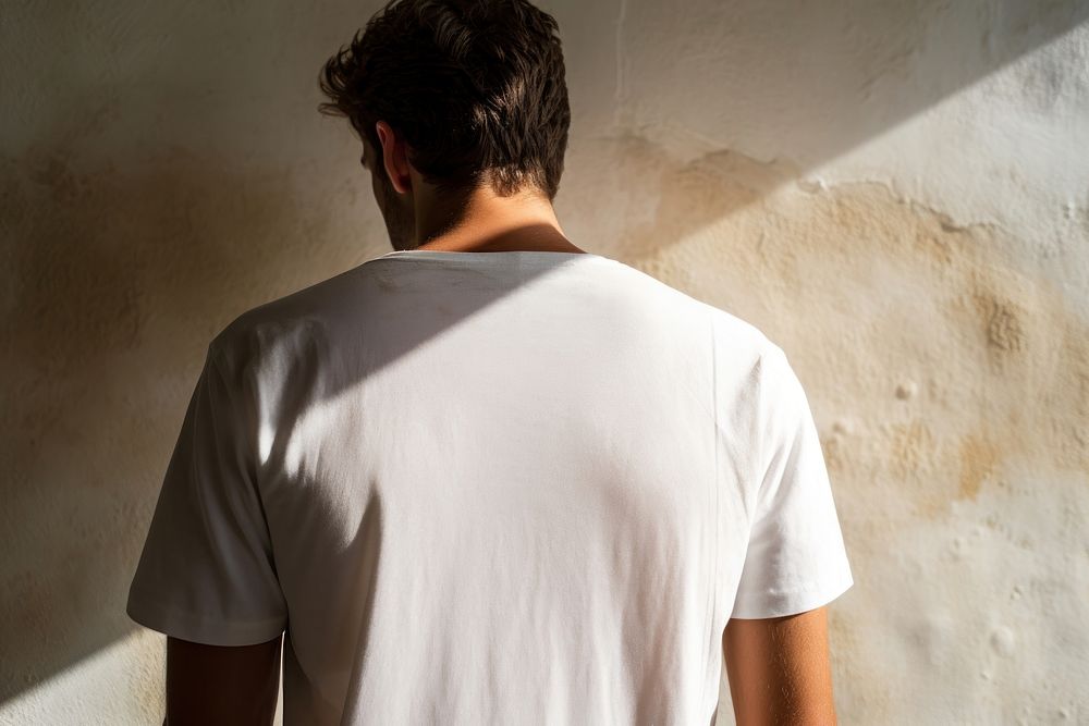A man in a white t shirt shadow adult back. AI generated Image by rawpixel.