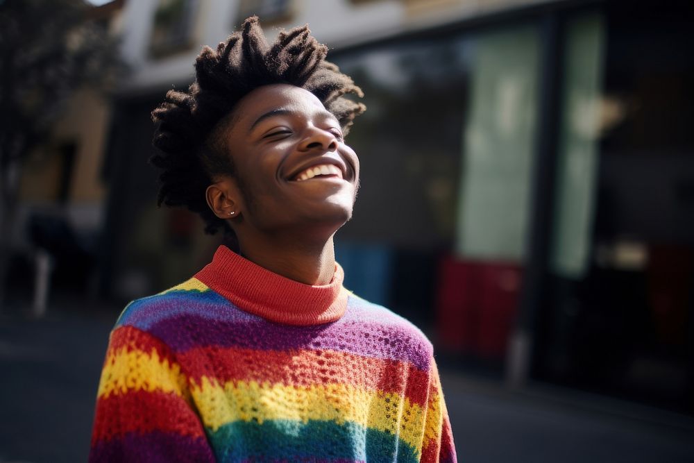 A black man in a rainbow knit shirt outdoors sweater smiling. AI generated Image by rawpixel.