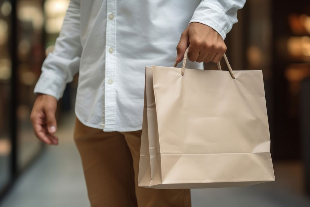 A man holding a white paper shopping bag handbag adult consumerism. AI generated Image by rawpixel.