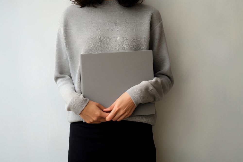 A woman with a black jumper holding a gray blank folder sweater sleeve accessories. AI generated Image by rawpixel.