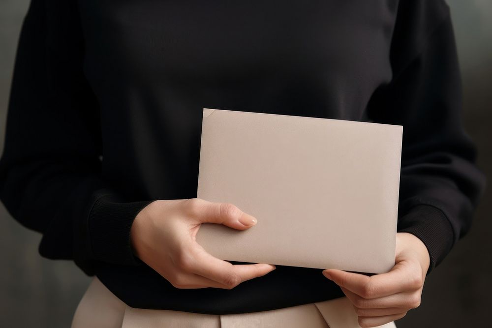 A woman with a black jumper holding a gray blank folder accessories electronics midsection. AI generated Image by rawpixel.