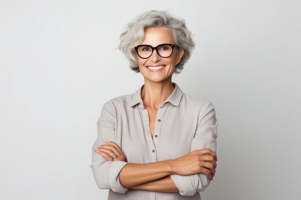 A smiling woman stands with her arms crossed portrait glasses adult. AI generated Image by rawpixel.