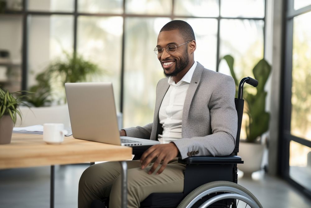 Afican male with a disability wheelchair computer sitting. 