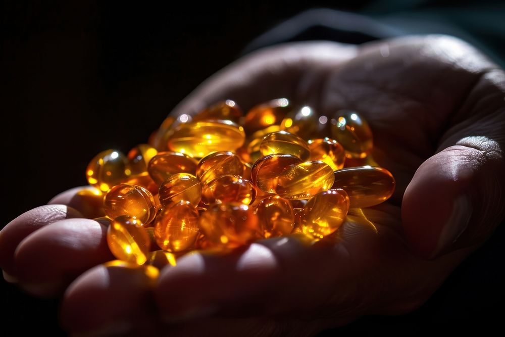 Fish oil pills gemstone jewelry holding. AI generated Image by rawpixel.