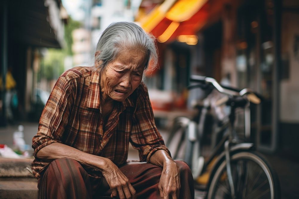 Senior lady sit and cry at street bicycle adult transportation. AI generated Image by rawpixel.