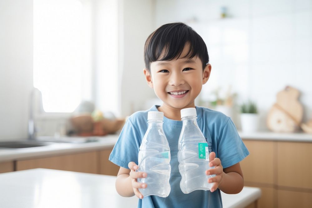 Kid holding empty clean plastic bottles kitchen smile child. AI generated Image by rawpixel.