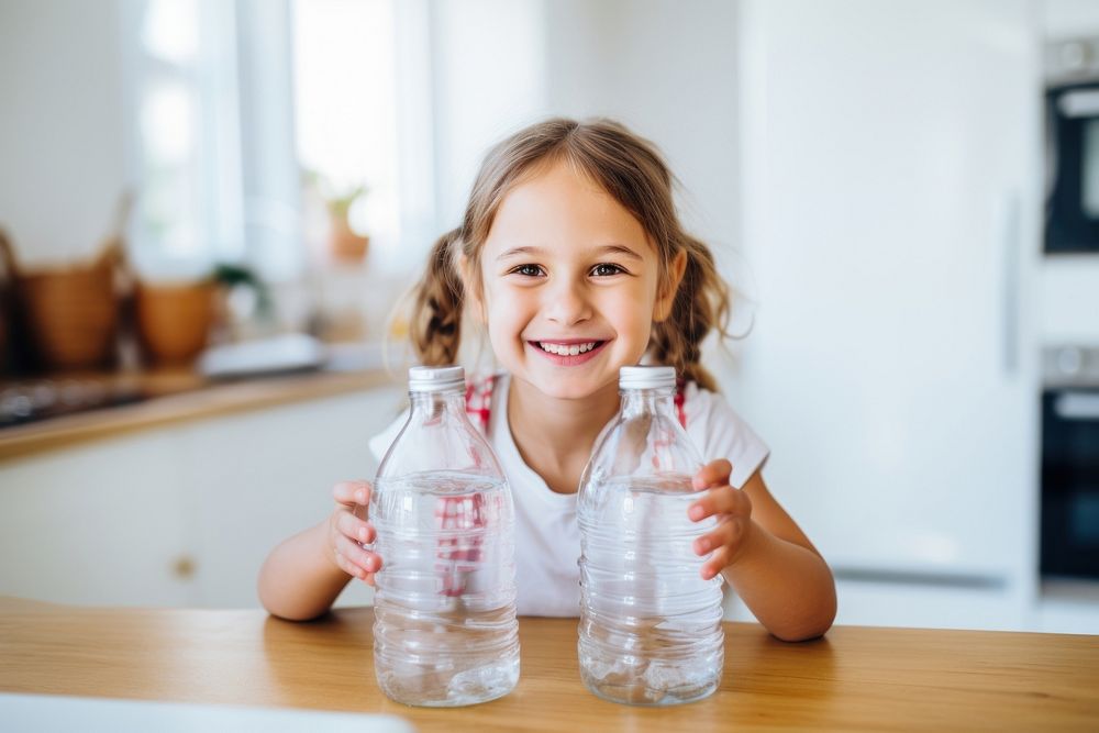 Kid holding empty clean plastic bottles smile refreshment container. AI generated Image by rawpixel.