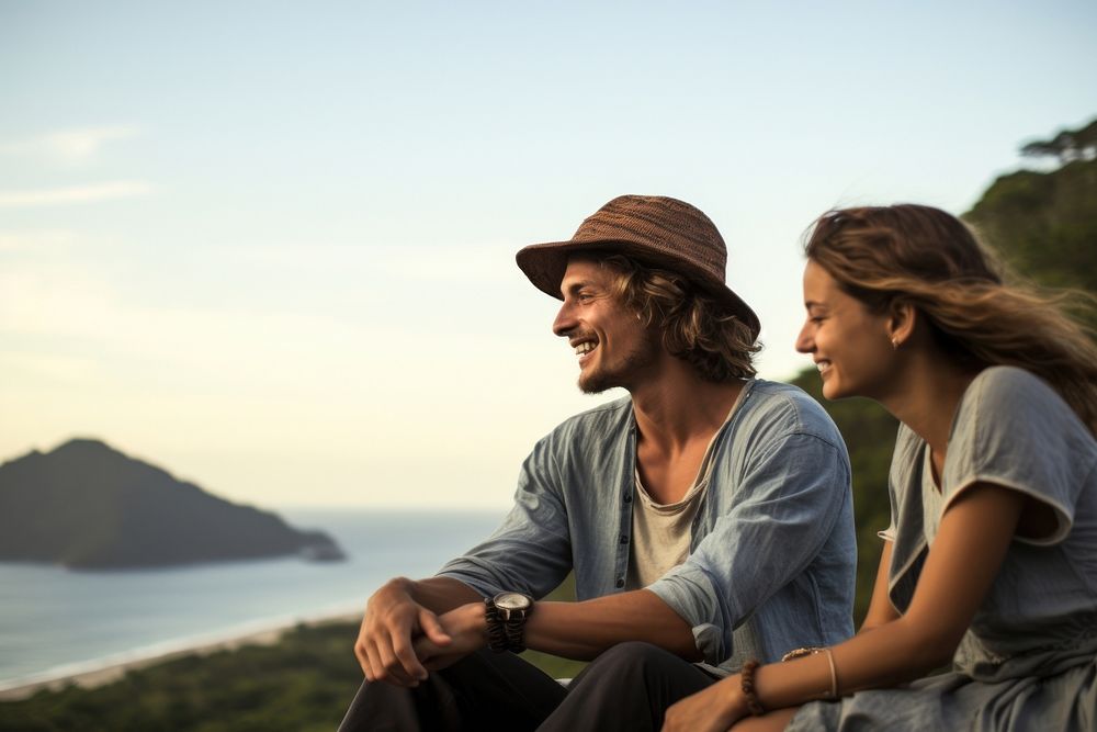 Two Latin Brazilian tourists sitting happily on a hill portrait outdoors travel. AI generated Image by rawpixel.