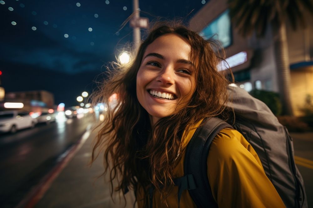 A Latina Brazilian female backpacker joyfully exploring Los Angeles during the nighttime portrait laughing travel. AI…