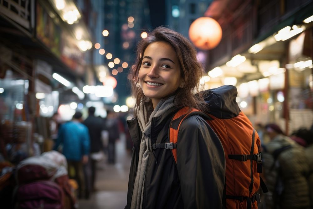 A Latina Brazilian female backpacker having fun exploring the night markets in Hong Kong portrait travel jacket. AI…