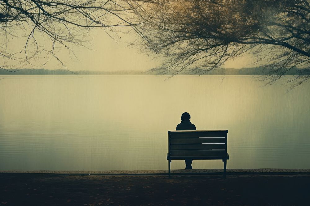 A woman sitting on a bench reading a book outdoors nature contemplation. AI generated Image by rawpixel.