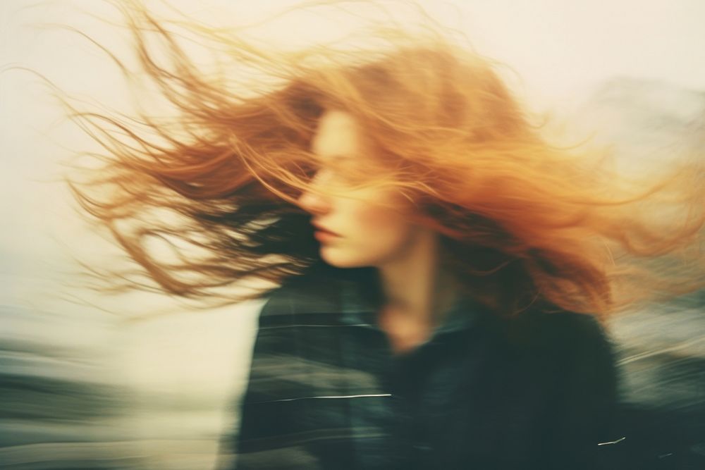 A woman with her hair blowing in the wind photography portrait contemplation. AI generated Image by rawpixel.