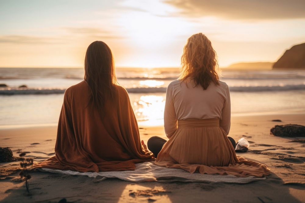Female friends sitting in a lotus pose beach meditating outdoors. AI generated Image by rawpixel.