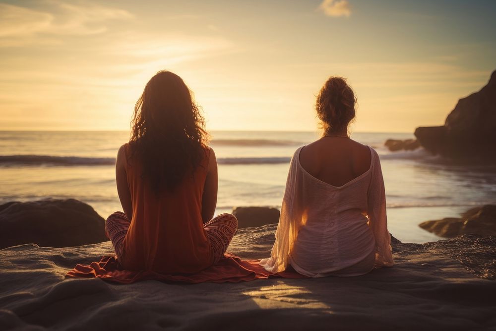 Female friends sitting in a lotus pose meditating beach adult. AI generated Image by rawpixel.