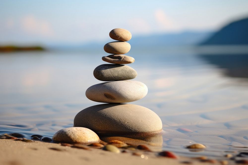 Stones stacked in the sand pebble sea tranquility. AI generated Image by rawpixel.