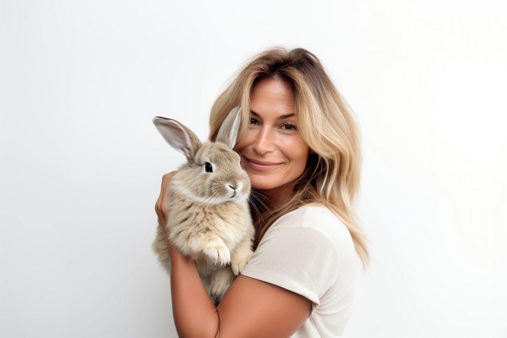 American middle age woman hugging rabbit portrait looking animal. AI generated Image by rawpixel.