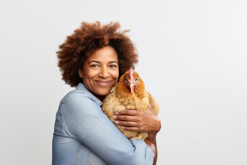 African american middle age woman hugging guinea pig chicken poultry animal. AI generated Image by rawpixel.