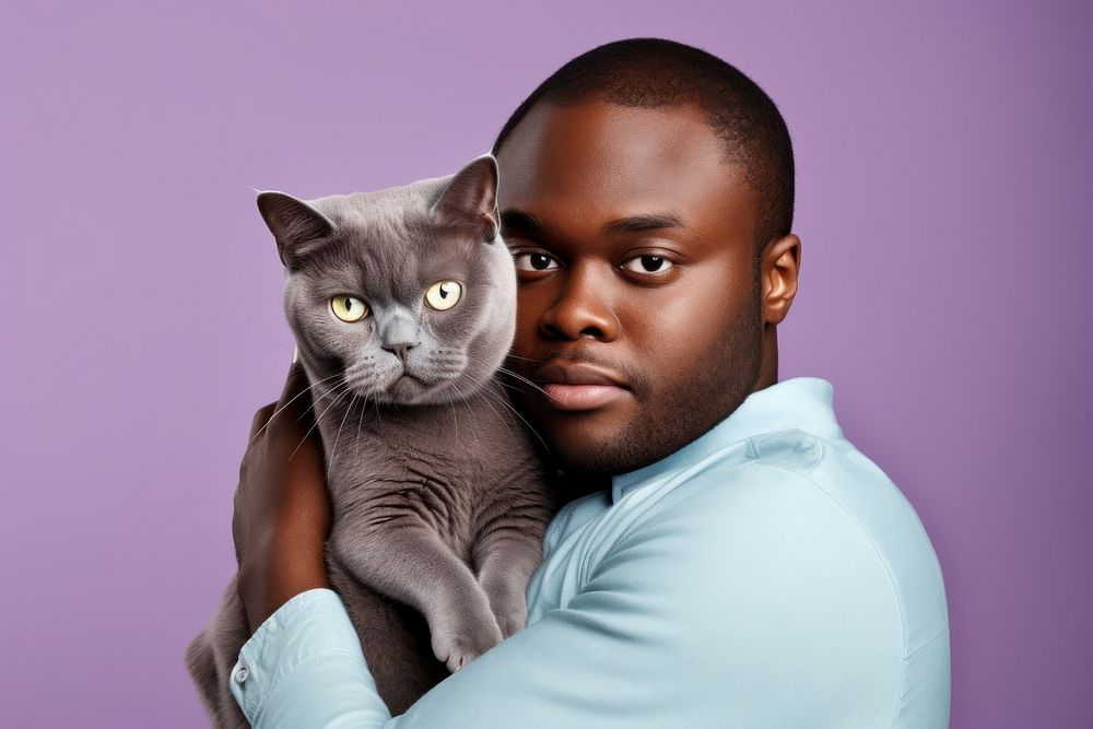 African middle age man hugging british shorthair cat pet portrait mammal. AI generated Image by rawpixel.