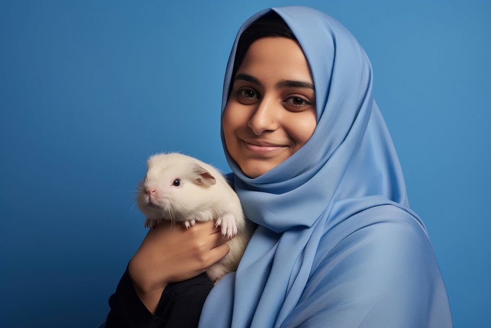 Middle east woman hugging guinea pig portrait looking animal. AI generated Image by rawpixel.
