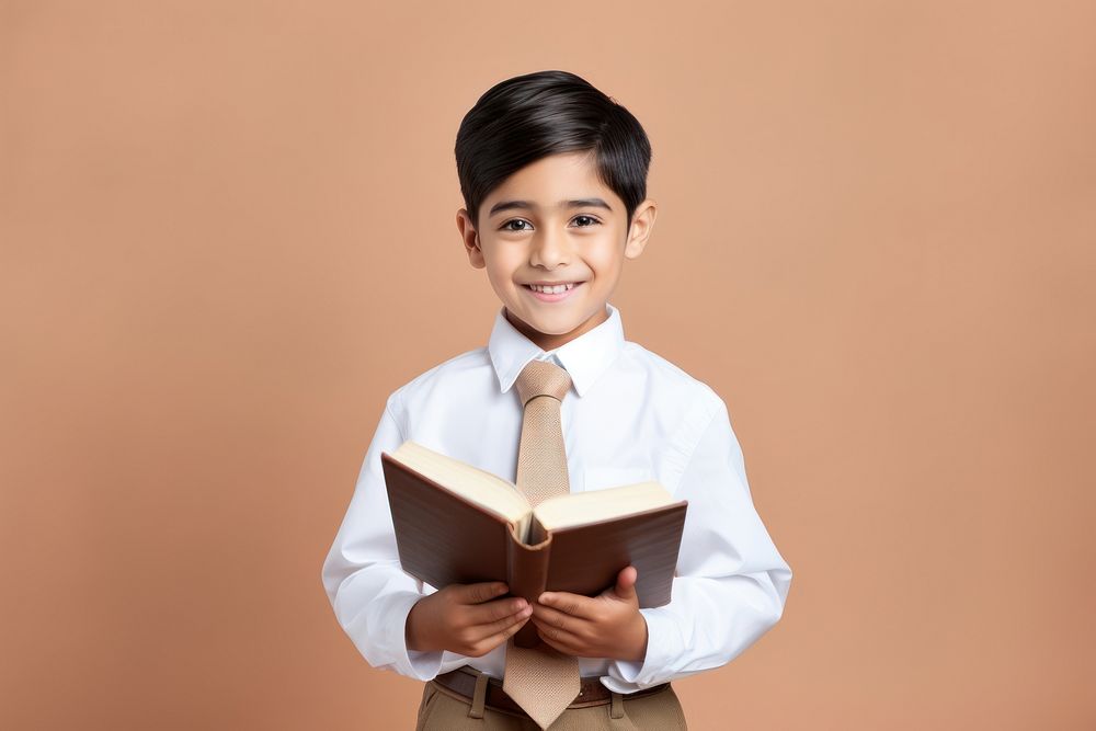 Kid in school uniform holding a book reading student intelligence. AI generated Image by rawpixel.