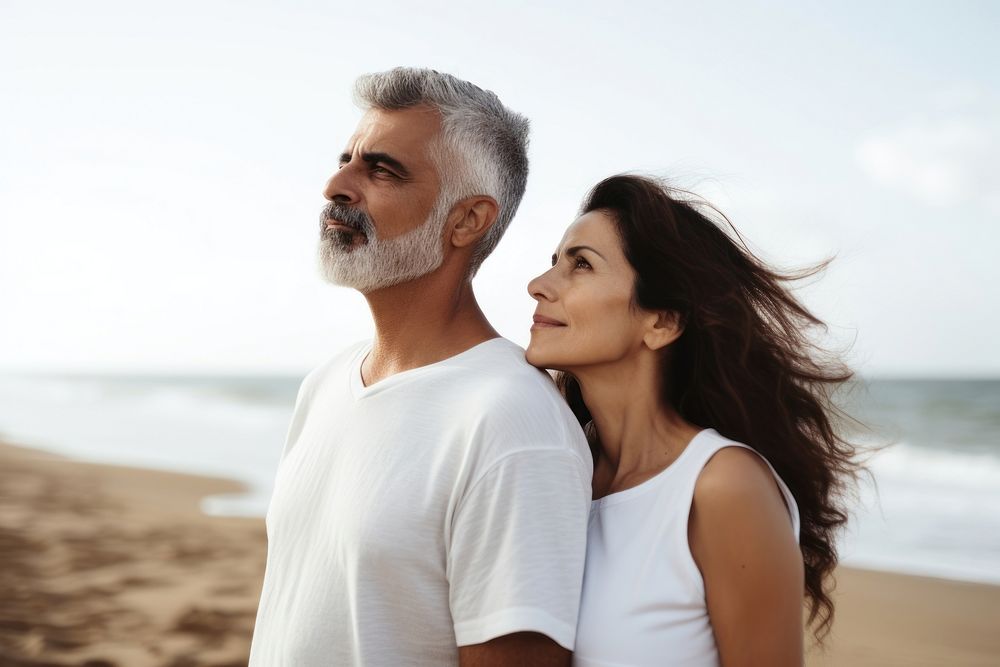 Latina brazillian middle age Loving couple standing at beach shore while looking away summer adult contemplation. AI…