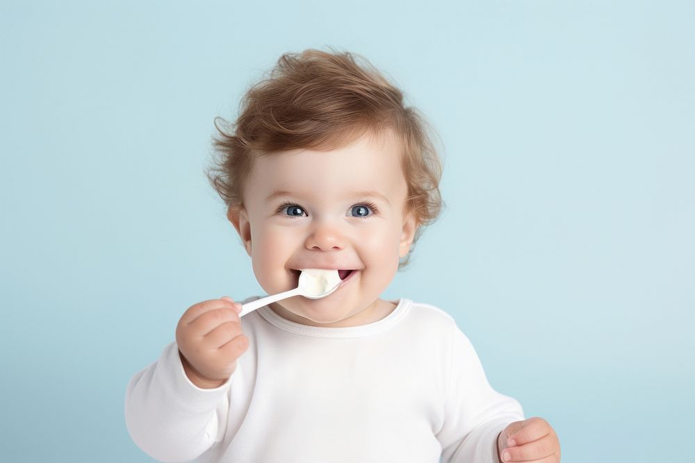 Baby enjoying with a spoon food toothbrush innocence. AI generated Image by rawpixel.