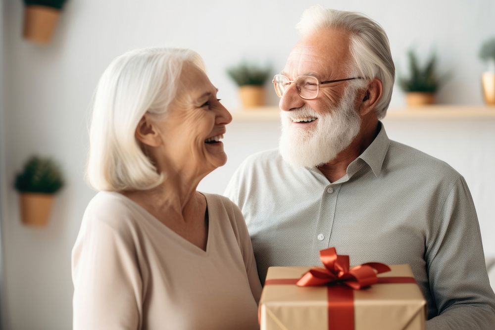Senior Man giving gift to smiling senior woman laughing adult happy. AI generated Image by rawpixel.
