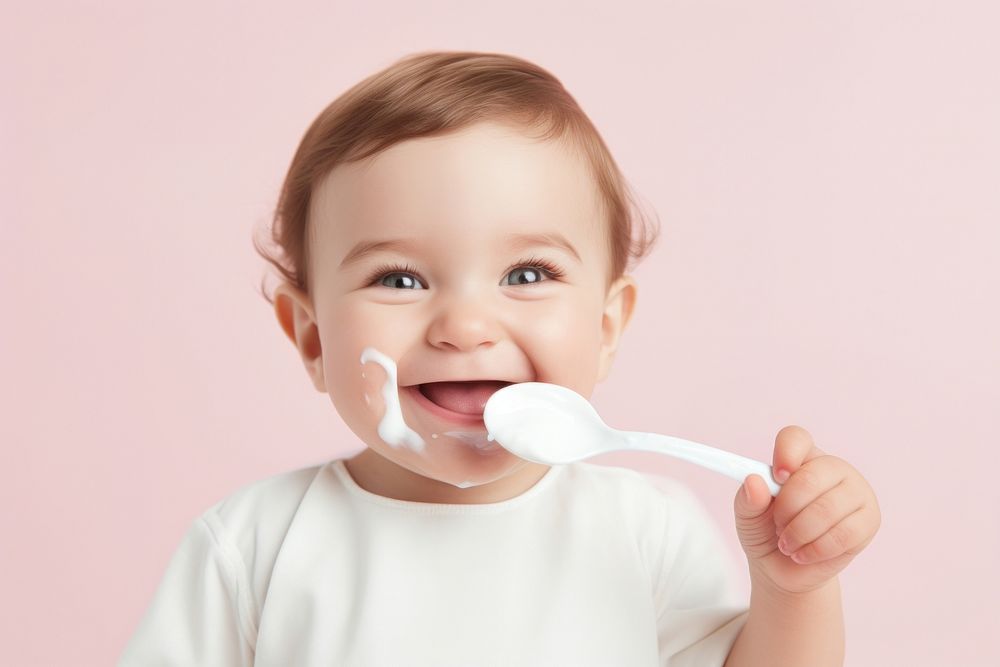 Baby enjoying with a spoon toothbrush innocence happiness. AI generated Image by rawpixel.