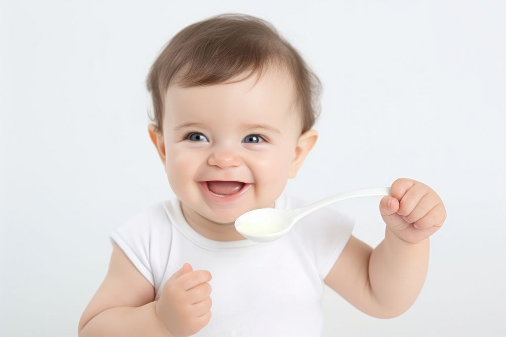Baby eats porridge spoon white background beginnings innocence. AI generated Image by rawpixel.