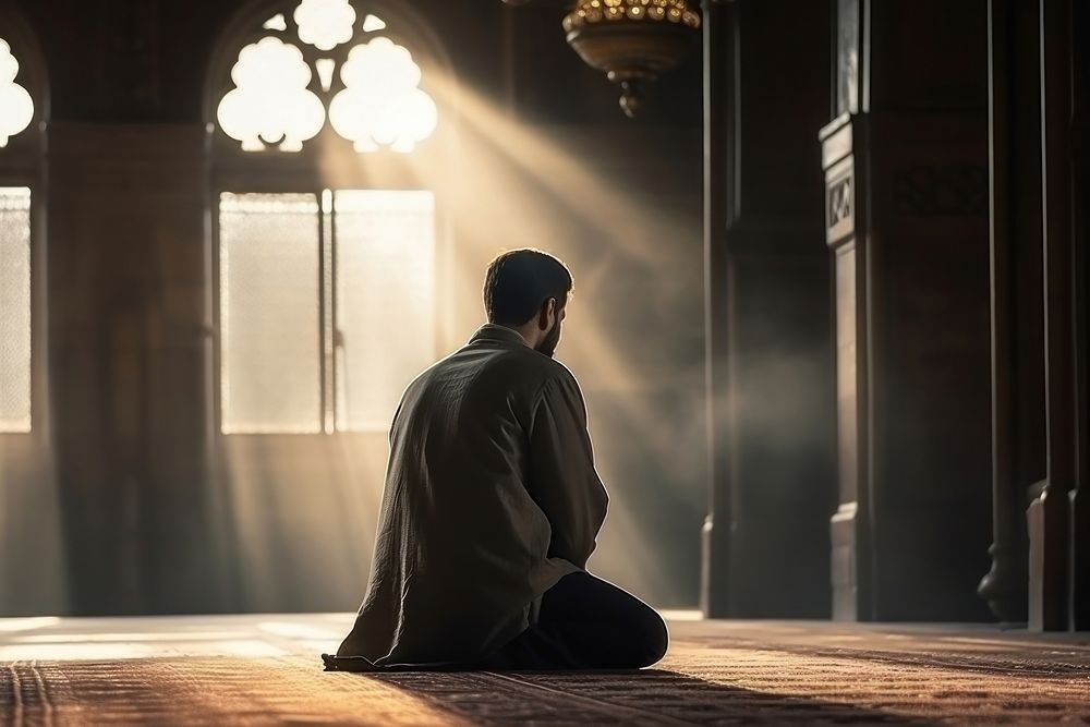 Muslim man praying sitting adult. AI generated Image by rawpixel.
