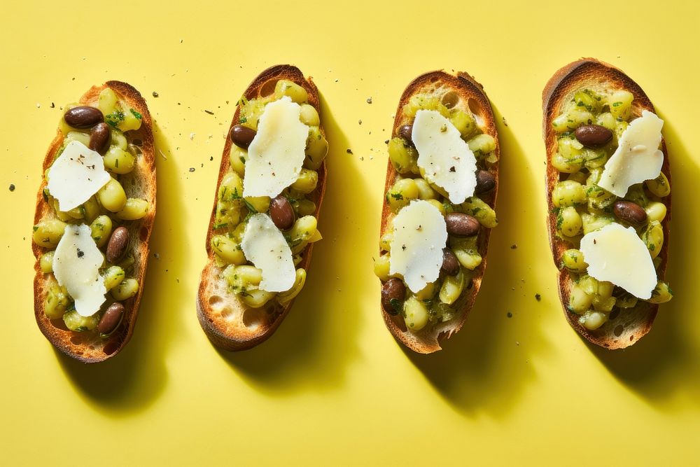 Broad bean and pecorino bruschetta yellow food yellow background. AI generated Image by rawpixel.