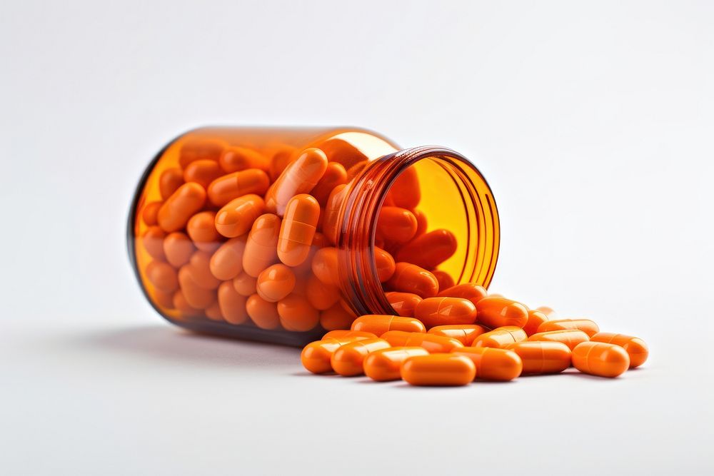Pills in bottle white background orange color antioxidant. AI generated Image by rawpixel.