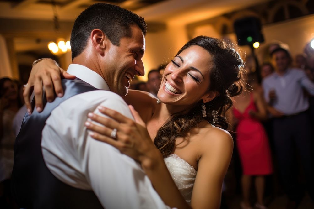 A vibrant moment during a Hispanic wedding celebration as the couple dances joyously at their reception happiness laughing…