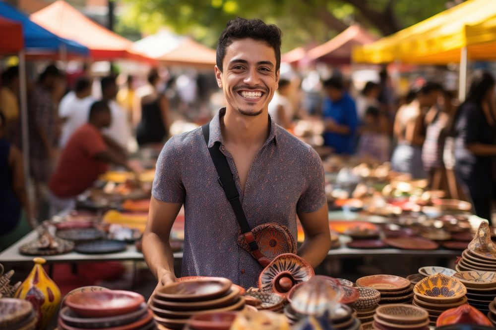 A young Latino entrepreneur showcasing handmade crafts at a vibrant street market adult smile celebration. AI generated…