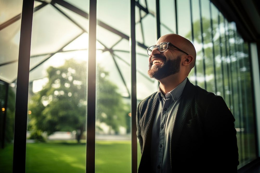 Man in glasses smiling laughing at a window portrait adult plant. AI generated Image by rawpixel.