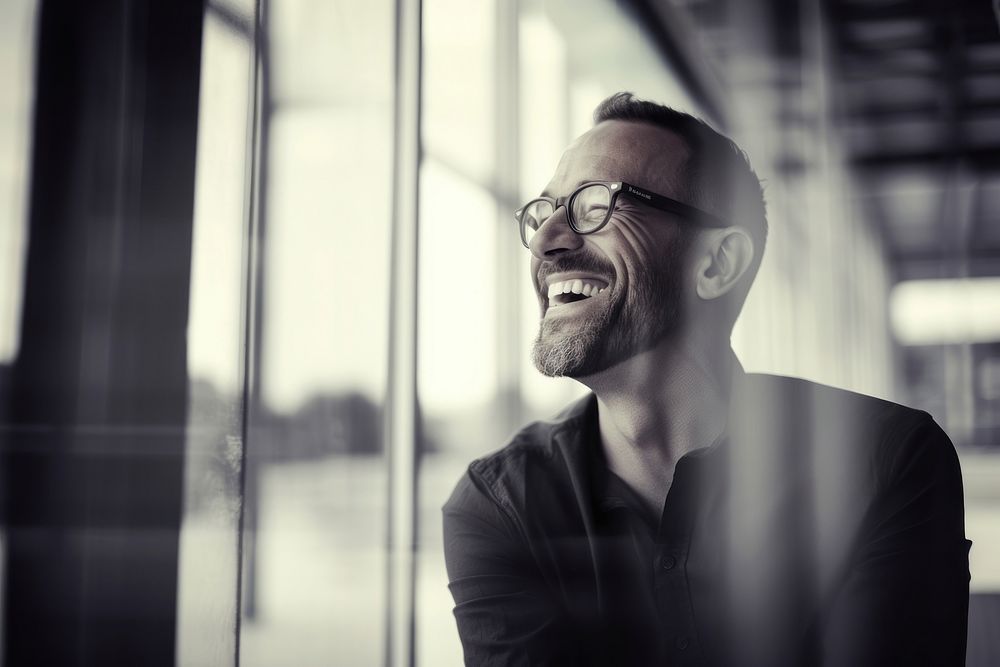 Man in glasses smiling laughing at a window adult smile human. AI generated Image by rawpixel.