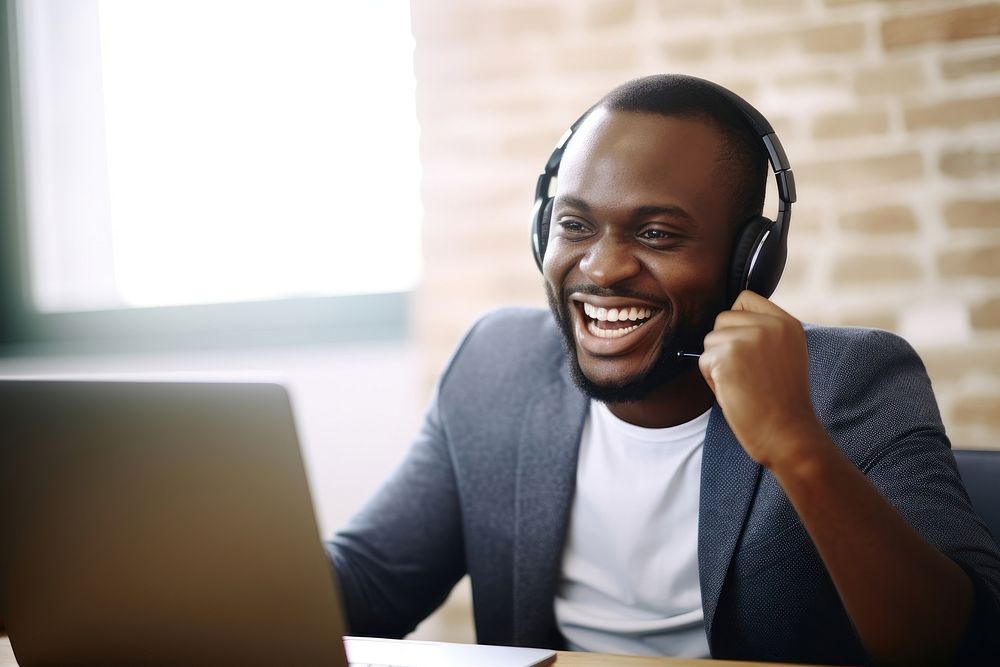 African American man headphones computer laughing. AI generated Image by rawpixel.