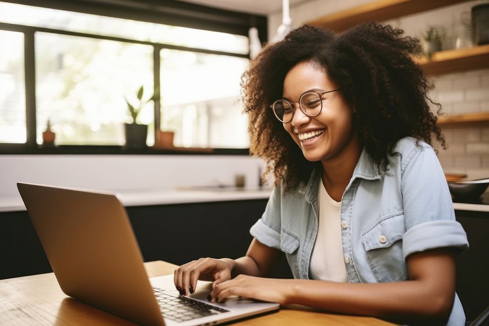 Young African student woman using laptop with glasses and smiling at home computer smile entrepreneur. AI generated Image by…