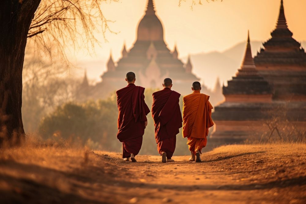 Monks are walking on dirt path in front of a temple in the background adult spirituality architecture. AI generated Image by…
