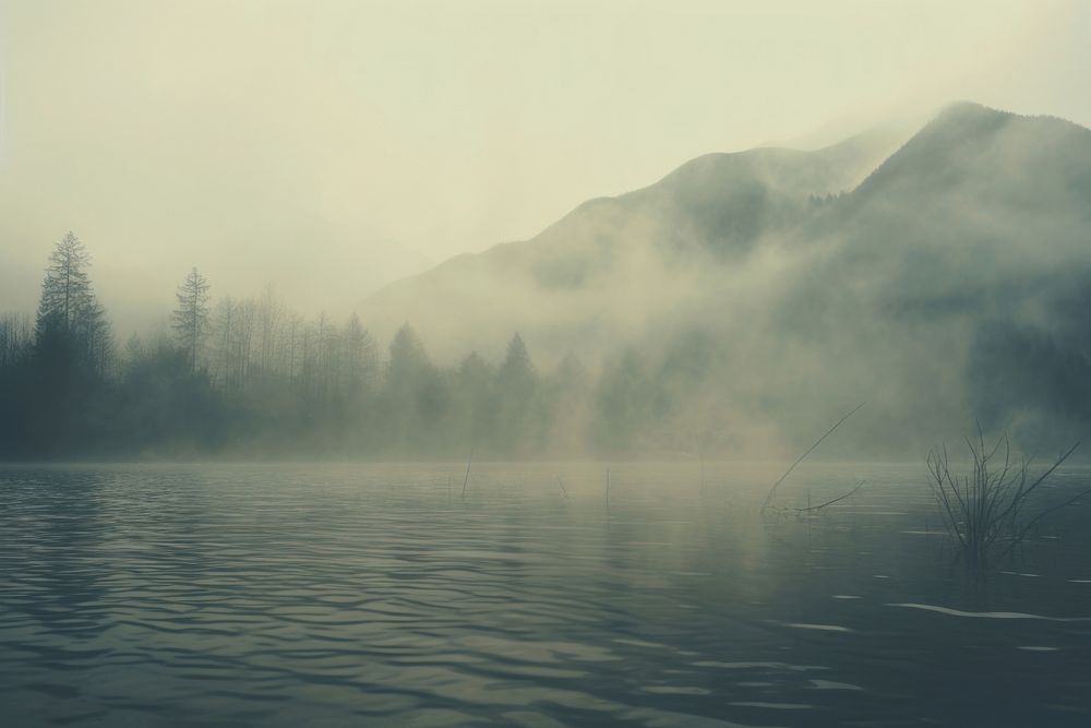 A lake with a mountain in the background mist outdoors nature. AI generated Image by rawpixel.