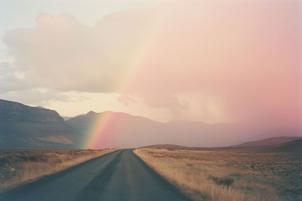A road wwith a mountain in the background rainbow landscape outdoors. AI generated Image by rawpixel.