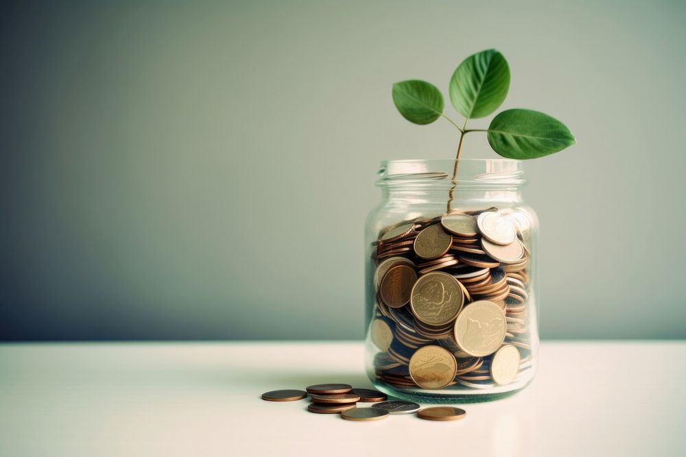 A glass jar filled with coins and a plant money investment medication. AI generated Image by rawpixel.