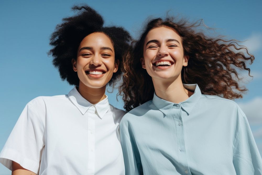 Two young mixed race woman smile laughing outdoors. AI generated Image by rawpixel.