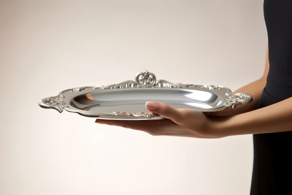 A butler waitress hand is holding up a silver platter jewelry accessories accessory. AI generated Image by rawpixel.