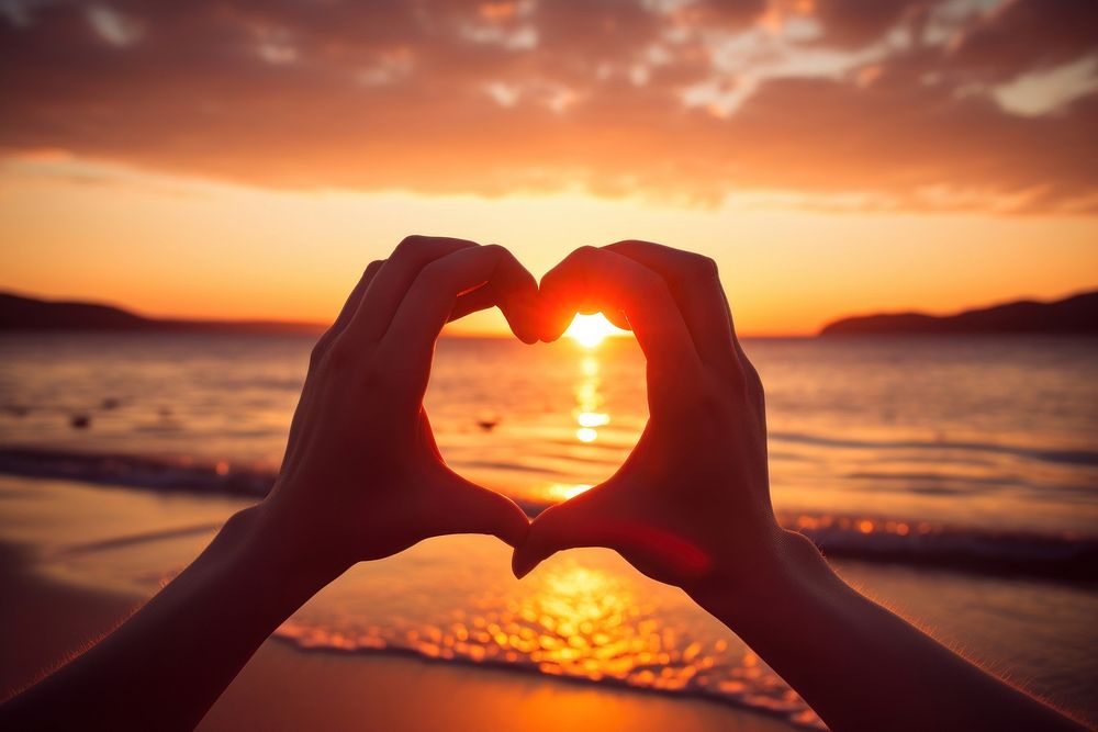 Hands in the silhouette of a heart outline beach adult sun. AI generated Image by rawpixel.