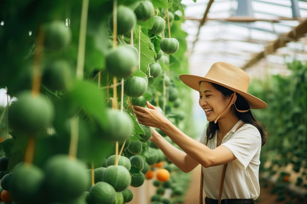 Happy asian farmer woman check quality products vegetable outdoors nature. AI generated Image by rawpixel.