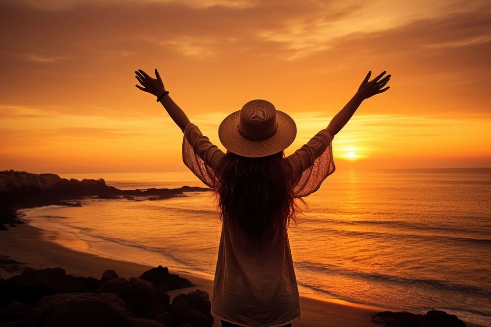Happy woman weating a hat with arms up enjoy freedom at the beach at sunset adult happy tranquility. AI generated Image by…